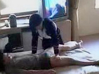 Hot and bothered Japanese busgirl fucks client's cock in Tokyo hotel room with Nippon XXX porn playing in background.